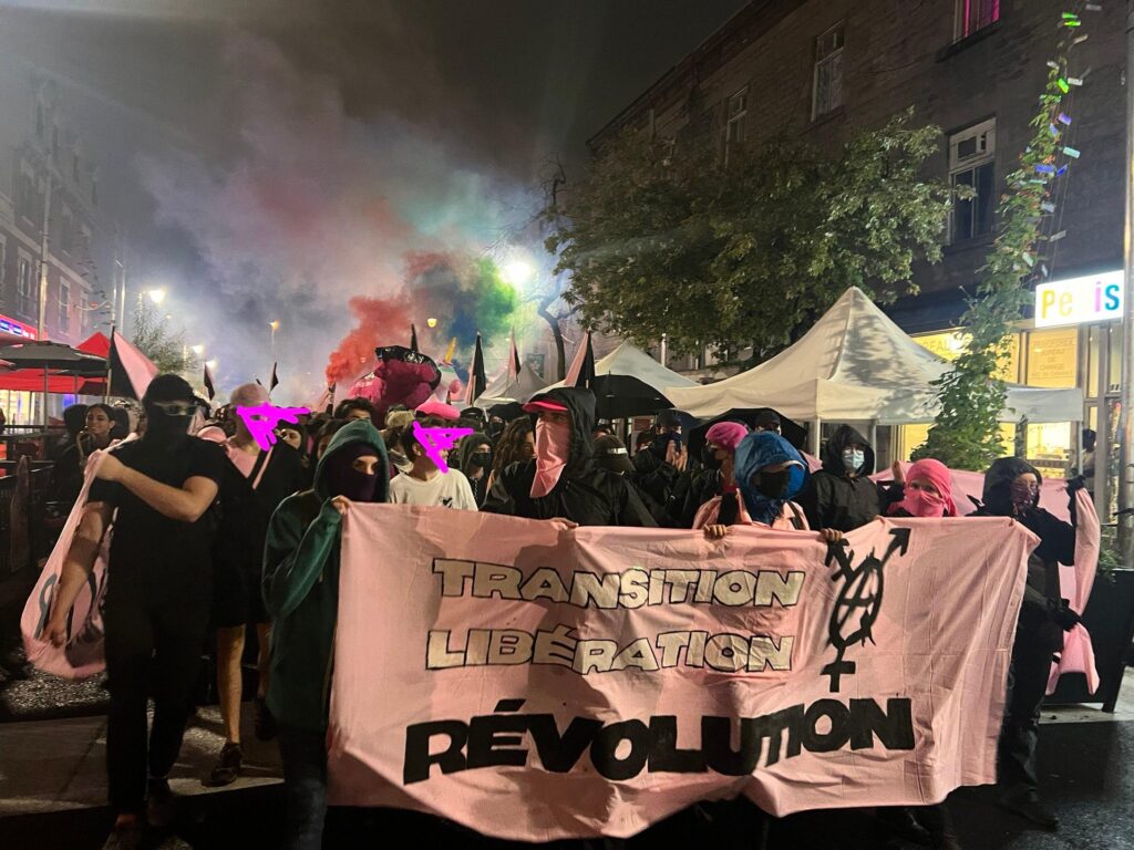 La tête de la manifestation, une bannière sur laquelle on lit "transition, libération, révolution"